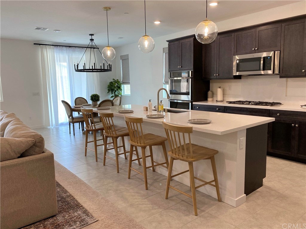 40274 Vivaldi Court Indio, CA 92203 - Photo 23 of 23 a kitchen with stainless steel appliances a table chairs sink and cabinets