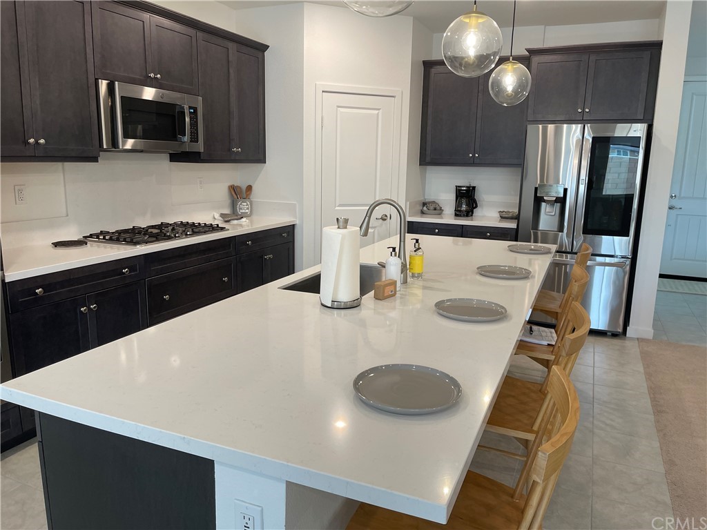 40274 Vivaldi Court Indio, CA 92203 - Photo 4 of 23 a kitchen with stainless steel appliances a stove microwave and sink