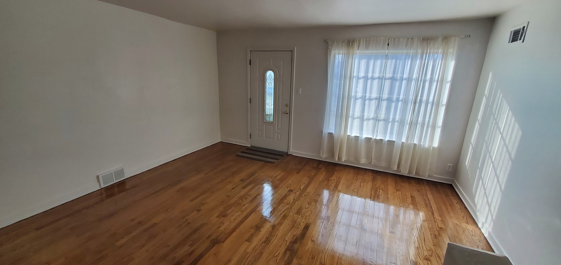 2305 South 15th Avenue Broadview, IL 60155 - Photo 2 of 6 an empty room with wooden floor and windows
