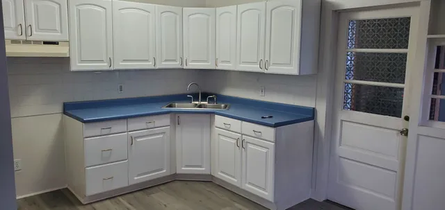 a kitchen with white cabinets and white appliances