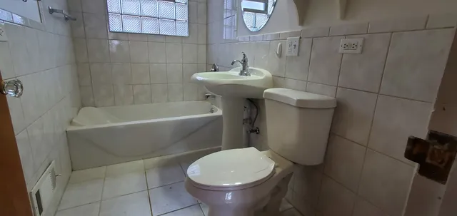 a white toilet sitting next to a white bath tub