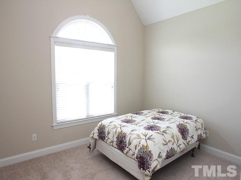1036 Newburgh Circle Raleigh, NC 27603 - Photo 14 of 25 a bed sitting in a bedroom next to a window
