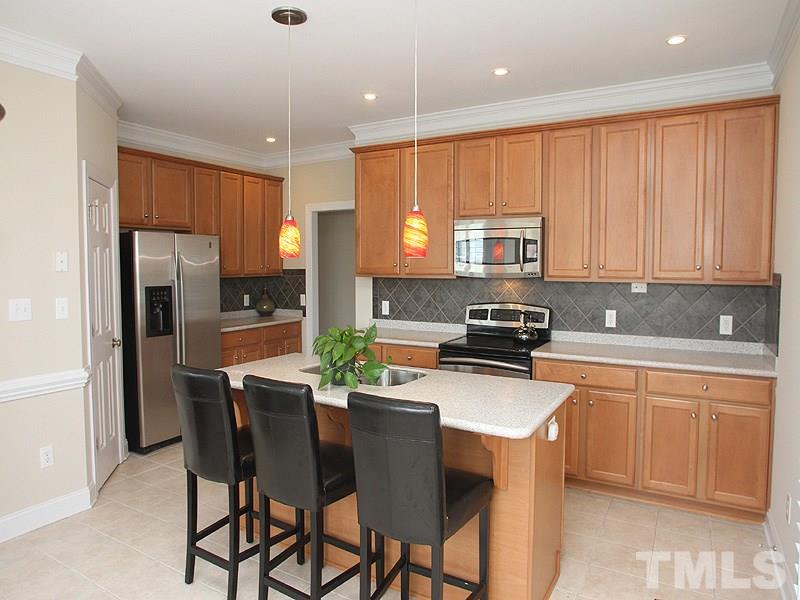 1036 Newburgh Circle Raleigh, NC 27603 - Photo 7 of 25 a kitchen with stainless steel appliances granite countertop a stove a sink a microwave a refrigerator and white cabinets
