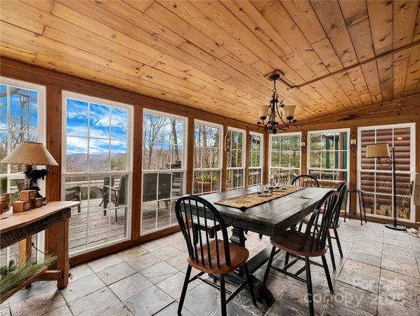 a dining room with furniture large windows and a chandelier