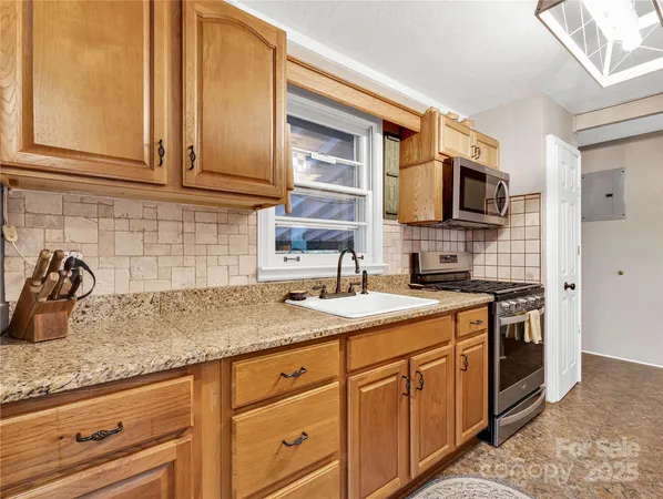 a kitchen with stainless steel appliances granite countertop a sink stove and microwave