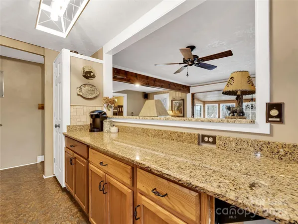 a kitchen with stainless steel appliances granite countertop a sink and cabinets with wooden floor