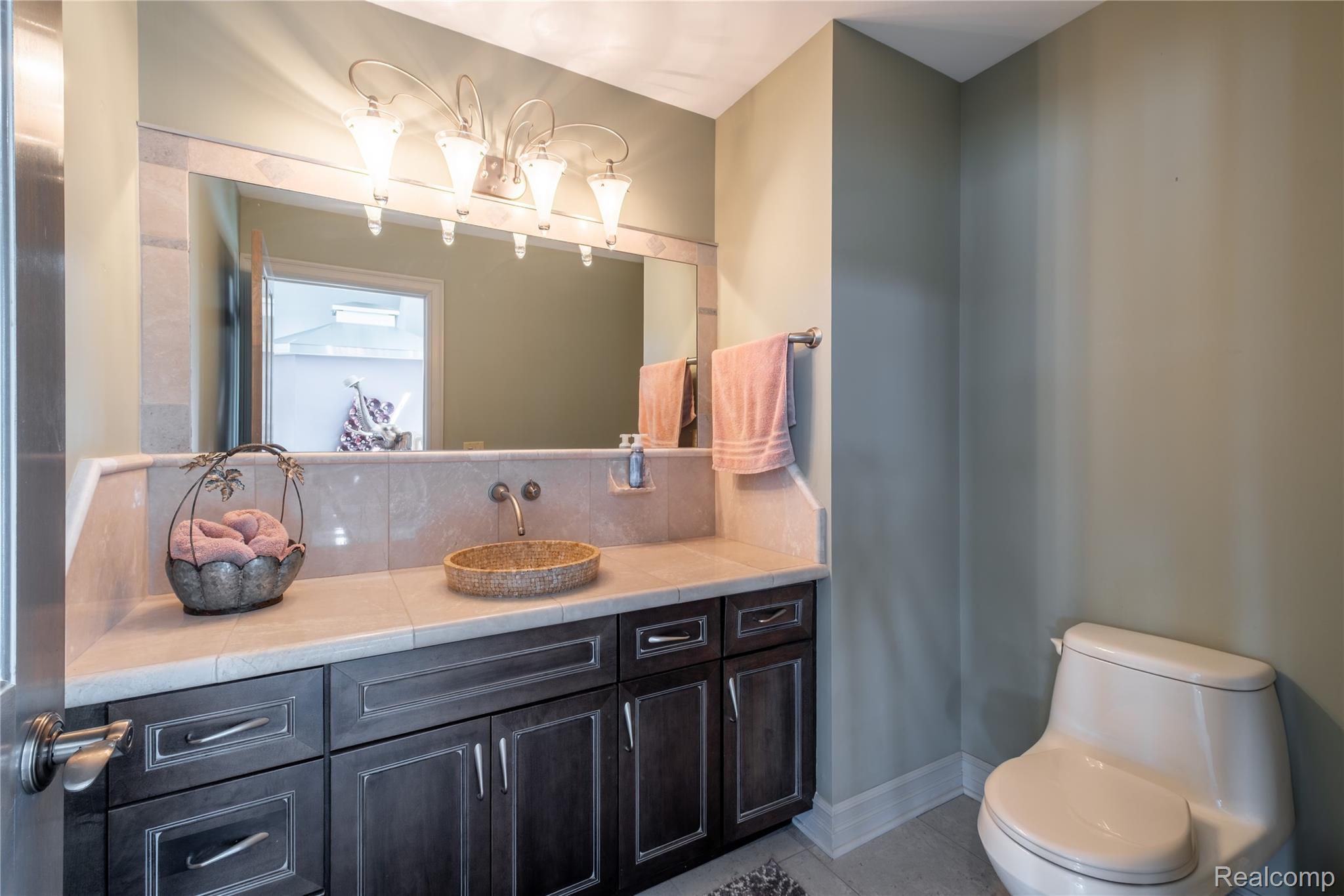 2350 Crane Road Fenton, MI 48430 - Photo 35 of 58 Bathroom featuring vanity, decorative backsplash, and light tile patterned flooring