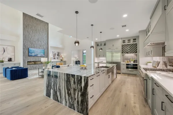 a large kitchen with stainless steel appliances lots of counter space and wooden floor