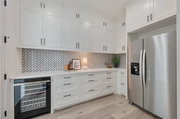 a kitchen with stainless steel appliances white cabinets and a refrigerator
