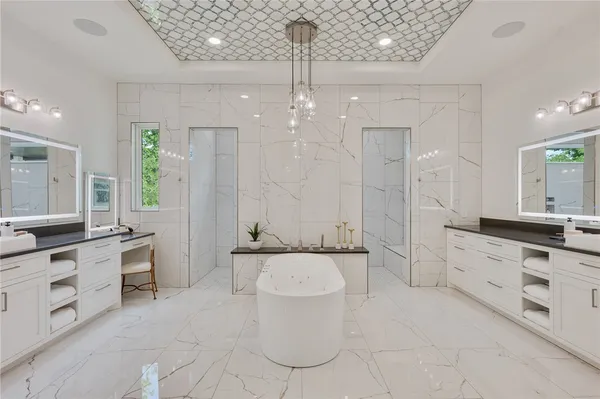 a large bathroom with a double vanity sink a toilet a mirror and shower