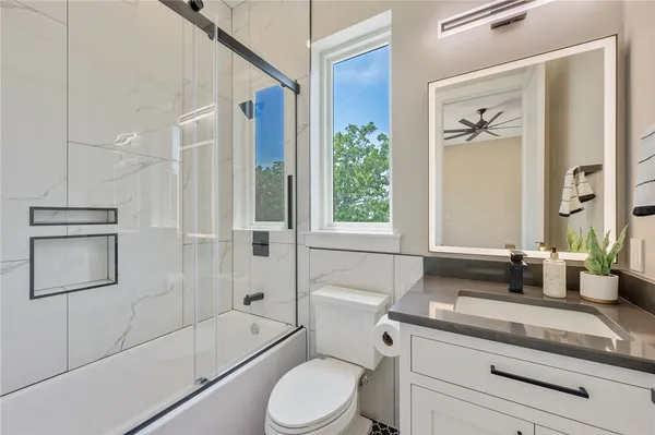 a bathroom with a granite countertop toilet a sink and a bathtub