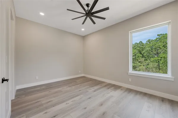 an empty room with a window and a ceiling fan