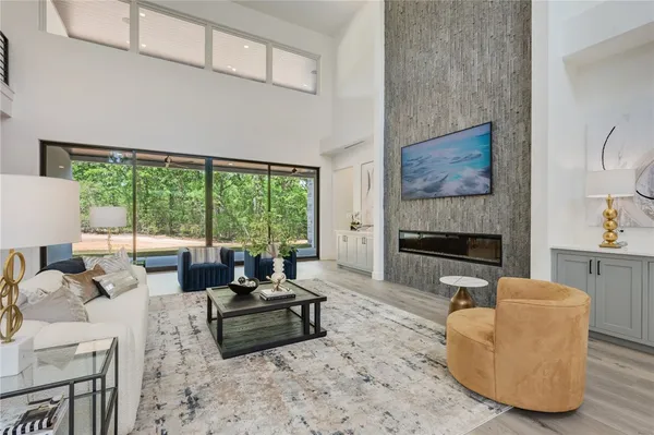 a living room with furniture fireplace and a large window