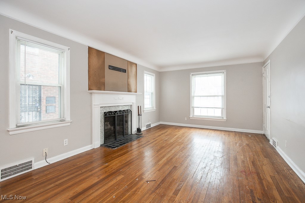 13545 Cedar Road Cleveland, OH 44118 - Photo 2 of 41 Unfurnished living room with dark wood finished floors, a high end fireplace, visible vents, and baseboards