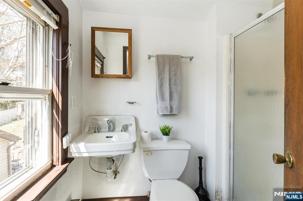 734 Broad Street Bloomfield, NJ 07003 - Photo 19 of 23 a bathroom with a toilet sink and mirror