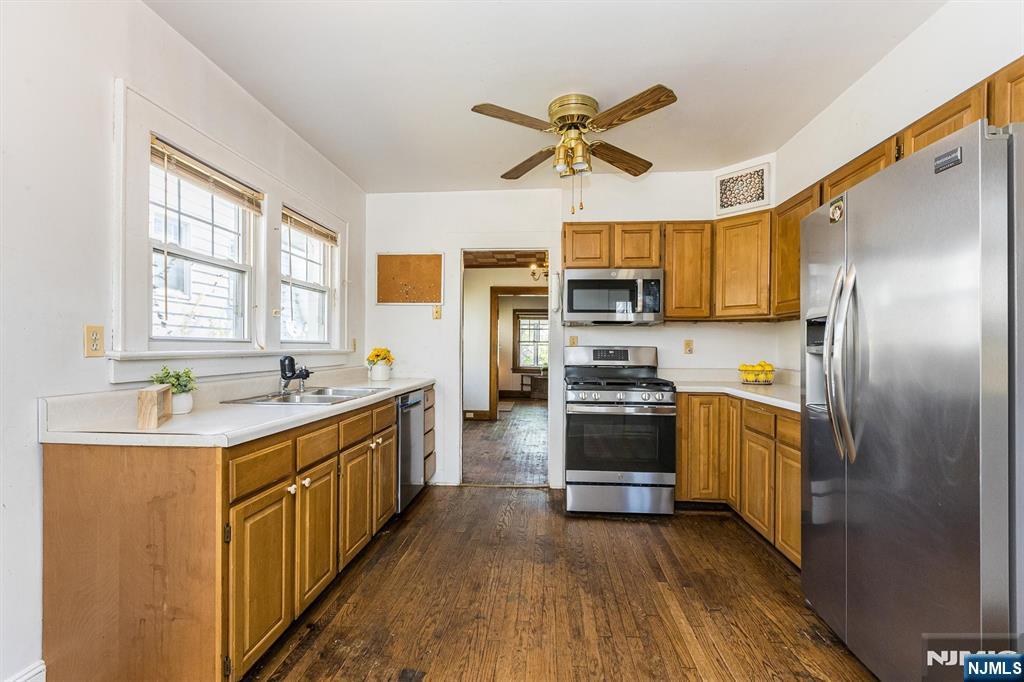 734 Broad Street Bloomfield, NJ 07003 - Photo 8 of 23 a kitchen with kitchen island granite countertop a sink cabinets stainless steel appliances and a window
