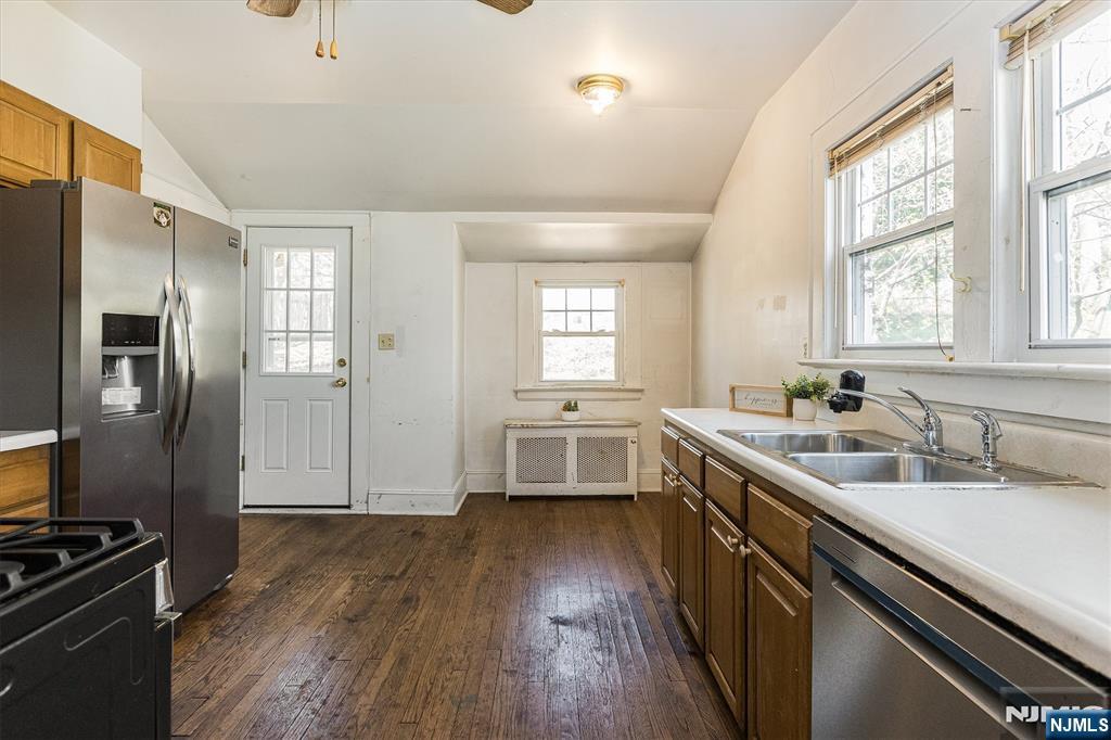 734 Broad Street Bloomfield, NJ 07003 - Photo 9 of 23 a kitchen with a sink wooden floor and stainless steel appliances