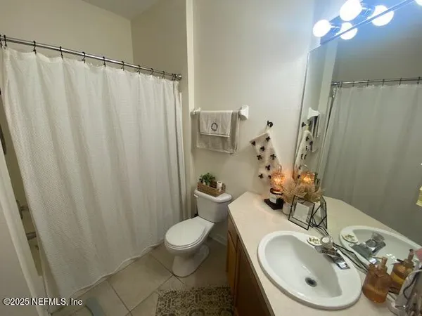 a bathroom with a sink a toilet and shower curtain