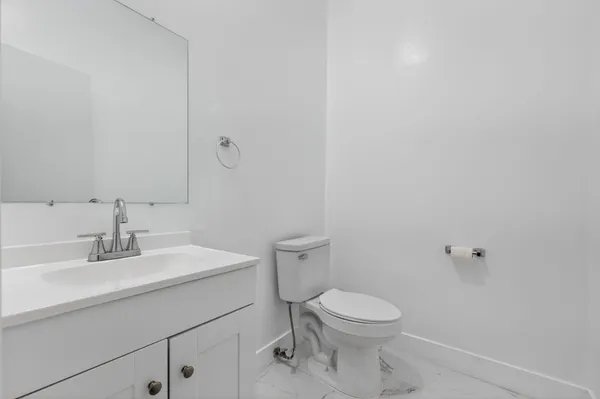 a bathroom with a toilet a sink and mirror
