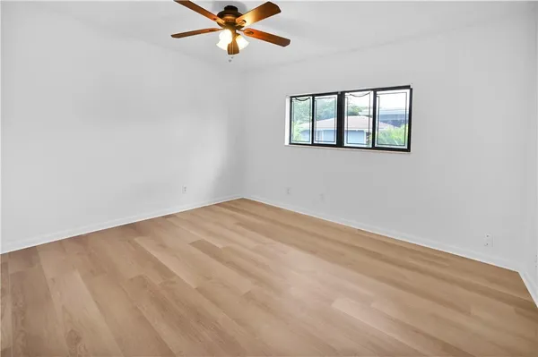 a view of a big room with wooden floor and windows