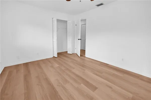 a view of an empty room with wooden floor
