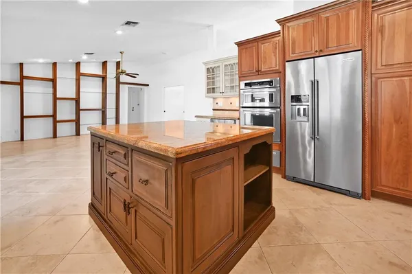 a kitchen with stainless steel appliances granite countertop a refrigerator a stove and a refrigerator