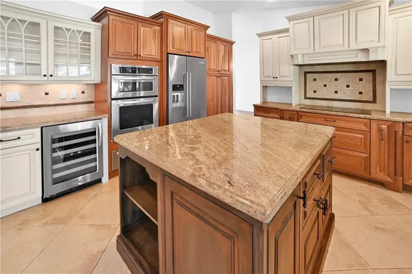 a kitchen with stainless steel appliances granite countertop a kitchen island a stove and a refrigerator