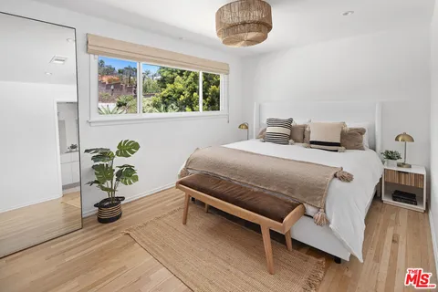 a bedroom with a bed and wooden floor