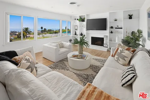 a living room with furniture a fireplace and a flat screen tv
