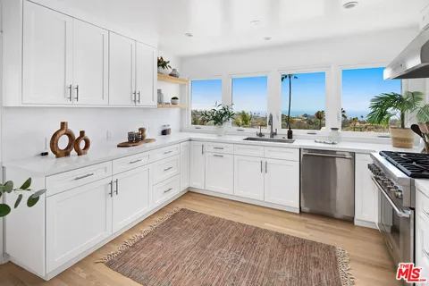 a kitchen with white cabinets sink and white appliances
