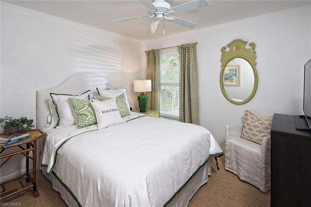 282 4th Street South, Unit 204 Naples, FL 34102 - Photo 7 of 16 a bedroom with a bed mirror and a window