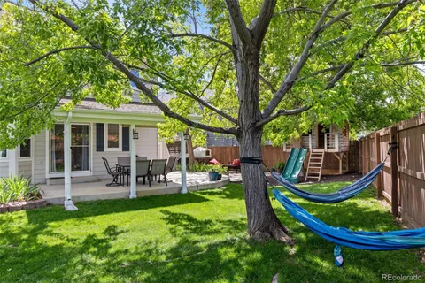a view of a chair and table in backyard of the house