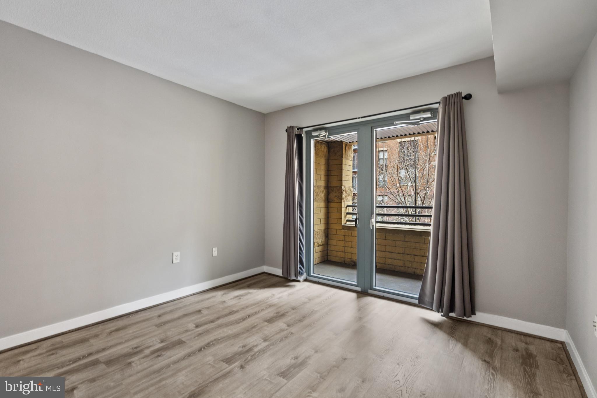 1117 10th Street Northwest, Unit 202 Washington, DC 20001 - Photo 12 of 29 an empty room with wooden floor and windows