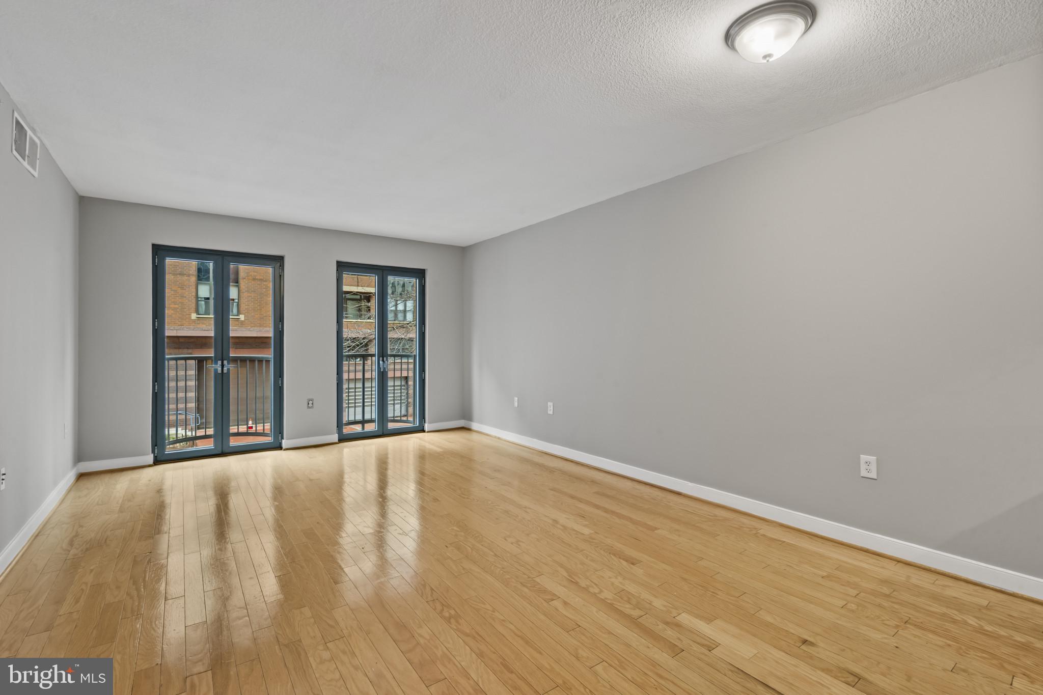1117 10th Street Northwest, Unit 202 Washington, DC 20001 - Photo 5 of 29 a view of an empty room with wooden floor and a window