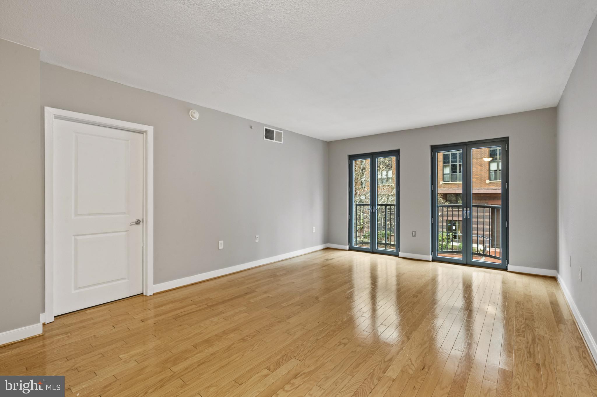 1117 10th Street Northwest, Unit 202 Washington, DC 20001 - Photo 6 of 29 a view of an empty room with wooden floor and a window