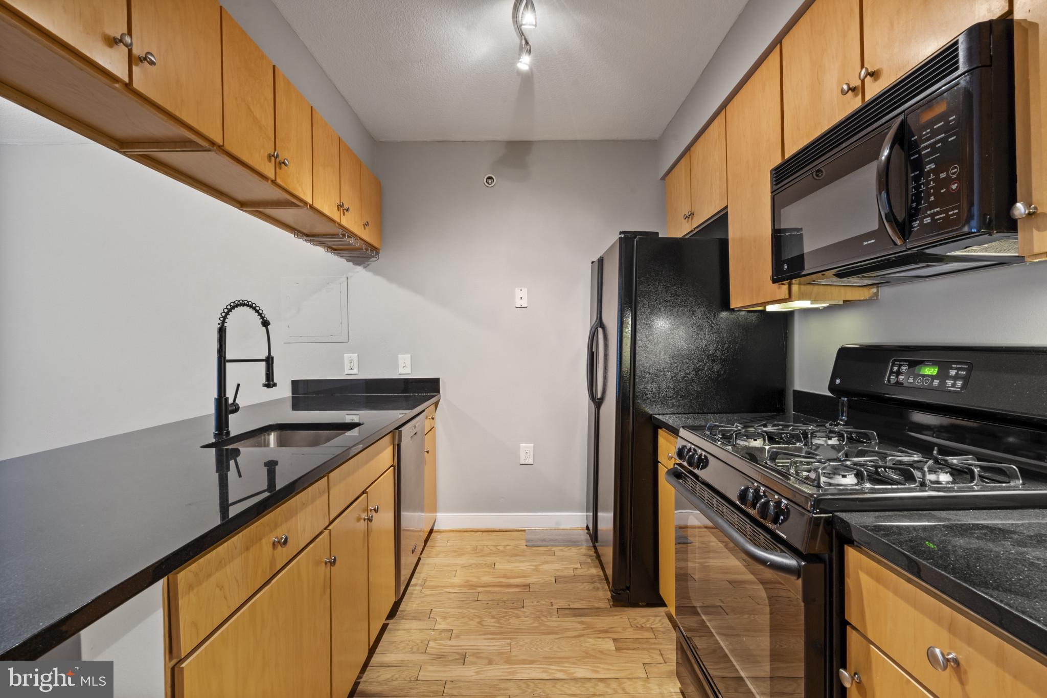 1117 10th Street Northwest, Unit 202 Washington, DC 20001 - Photo 7 of 29 a kitchen with stainless steel appliances granite countertop a sink a stove and a refrigerator
