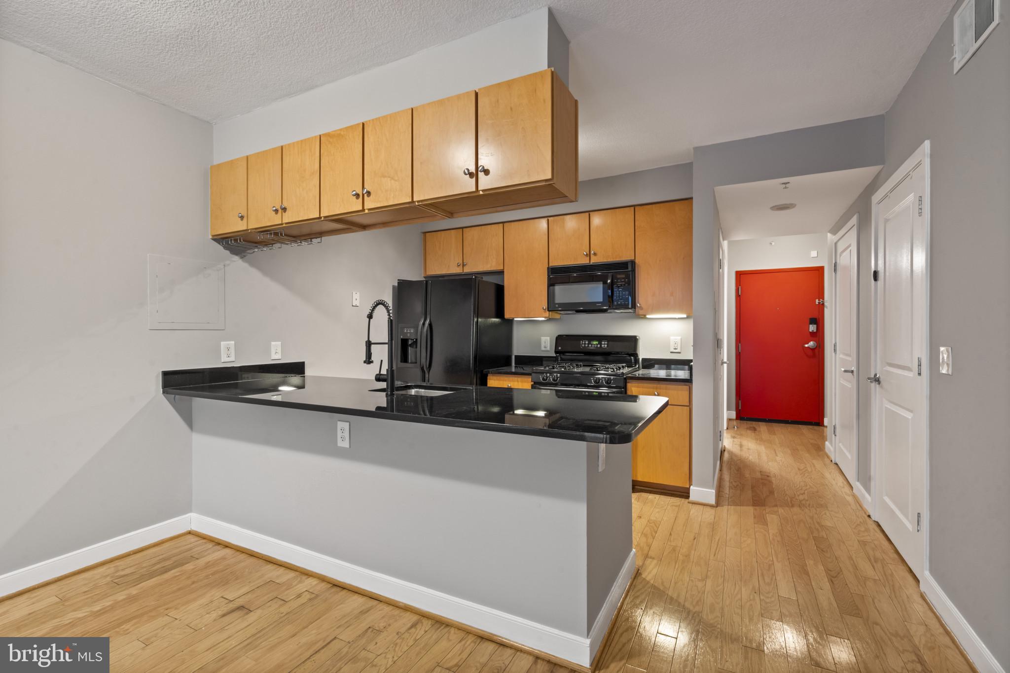 1117 10th Street Northwest, Unit 202 Washington, DC 20001 - Photo 8 of 29 a kitchen with stainless steel appliances granite countertop a sink stove and refrigerator