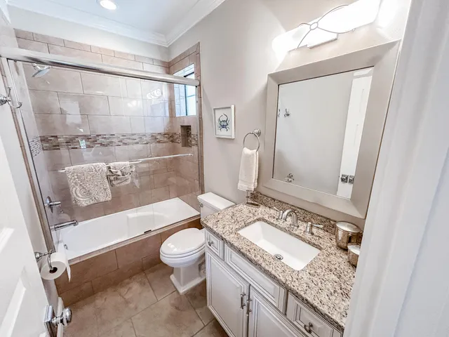a bathroom with a granite countertop sink toilet mirror and bathtub