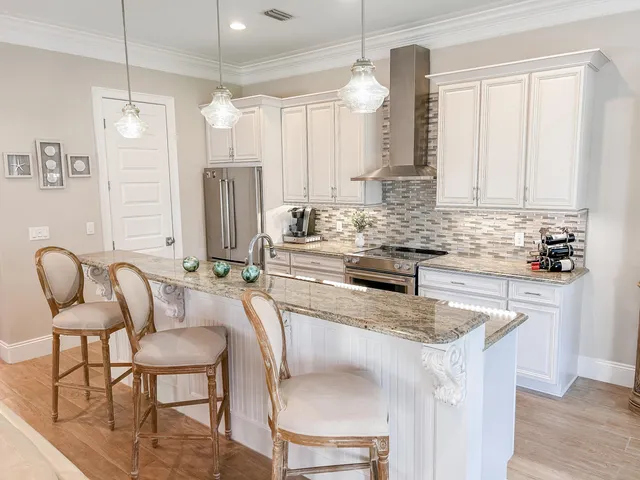 a kitchen with granite countertop white cabinets and stainless steel appliances