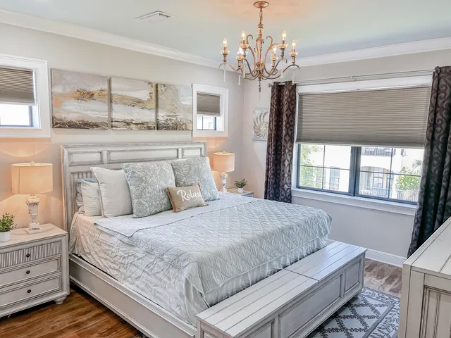 a bedroom with a large bed and a chandelier