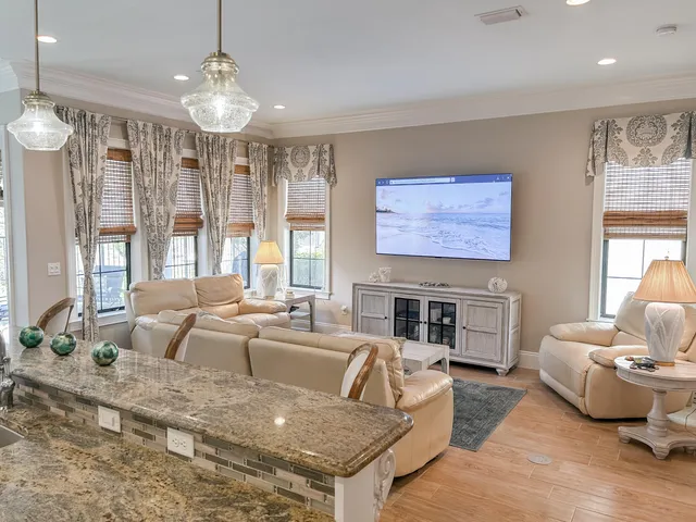 a living room with furniture fireplace and large windows
