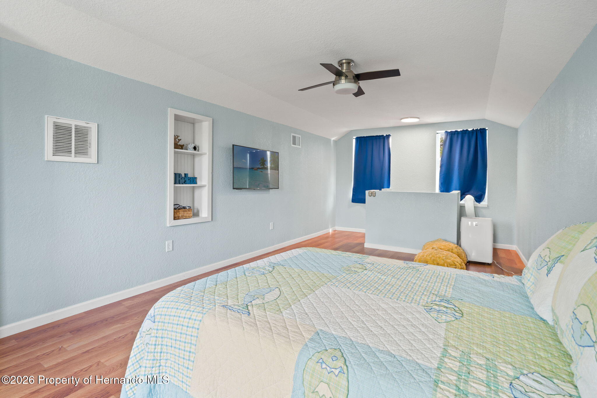 1566 Indian Bay Road Spring Hill, FL 34607 - Photo 29 of 56 a bedroom with a bed and wooden floor