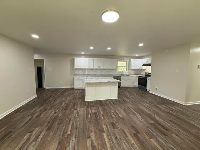 a view of kitchen view wooden floors appliances and cabinets