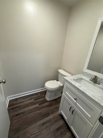 a bathroom with a granite countertop toilet and a sink