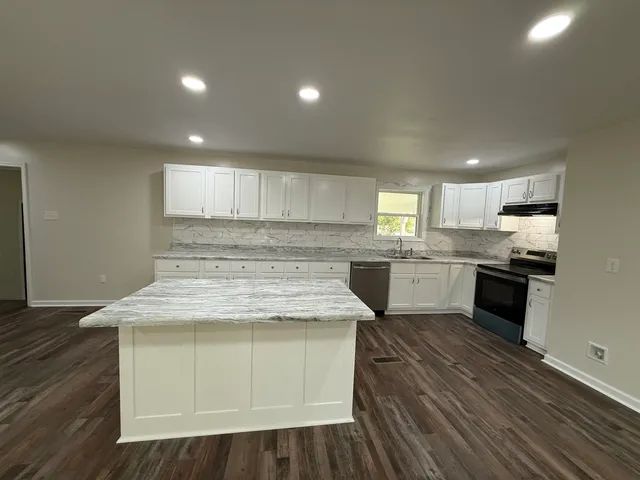 a kitchen with a sink window and cabinets