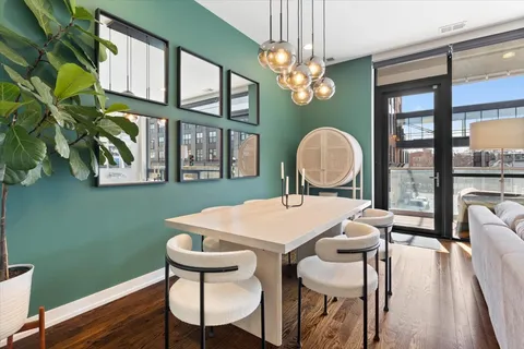 a view of a dining room with furniture a chandelier and wooden floor