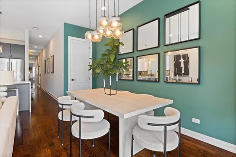 a view of a dining room with furniture a chandelier and wooden floor