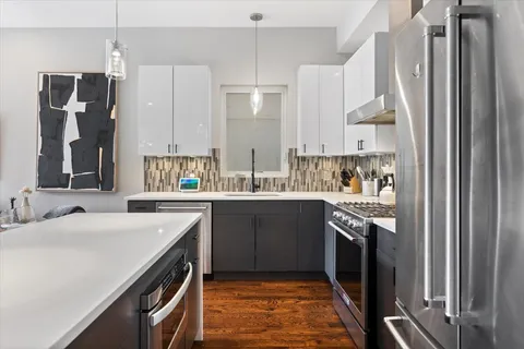 a kitchen with stainless steel appliances a sink stove and refrigerator