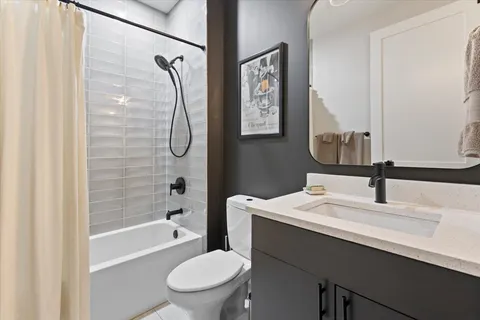 a bathroom with a granite countertop sink a toilet and shower