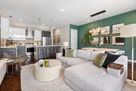 a living room with furniture kitchen and a large window